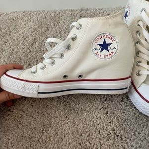 White high top converse that have a heel.